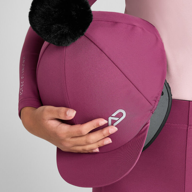 Junior rider in Aztec Diamond gear holds a Raspberry Pom Hat Silk by Aztec Diamond.