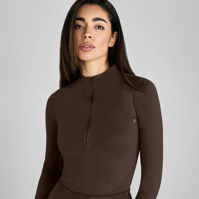 Woman in a fitted Aztec Diamond Core Baselayer Mocha against a plain grey background.