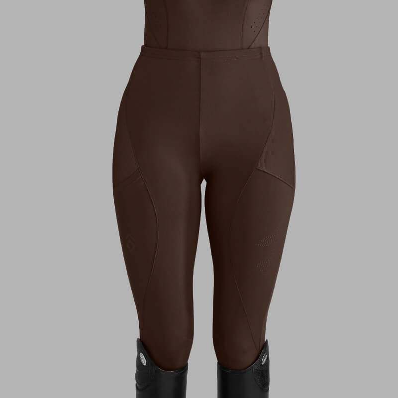 Model wears Aztec Diamond Core Leggings Knee Grip Mocha with tall black boots, gray background.