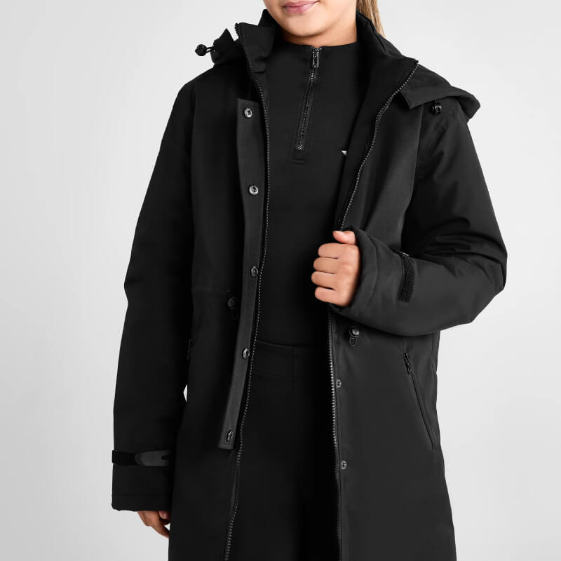Wearing the Aztec Diamond YR Fleece Lined Rain Jacket Black over a black outfit, coat partially open.