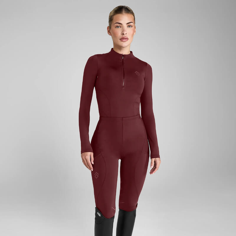 Woman in Aztec Diamond Core Leggings Knee Grip Cherry, standing by a plain gray background.