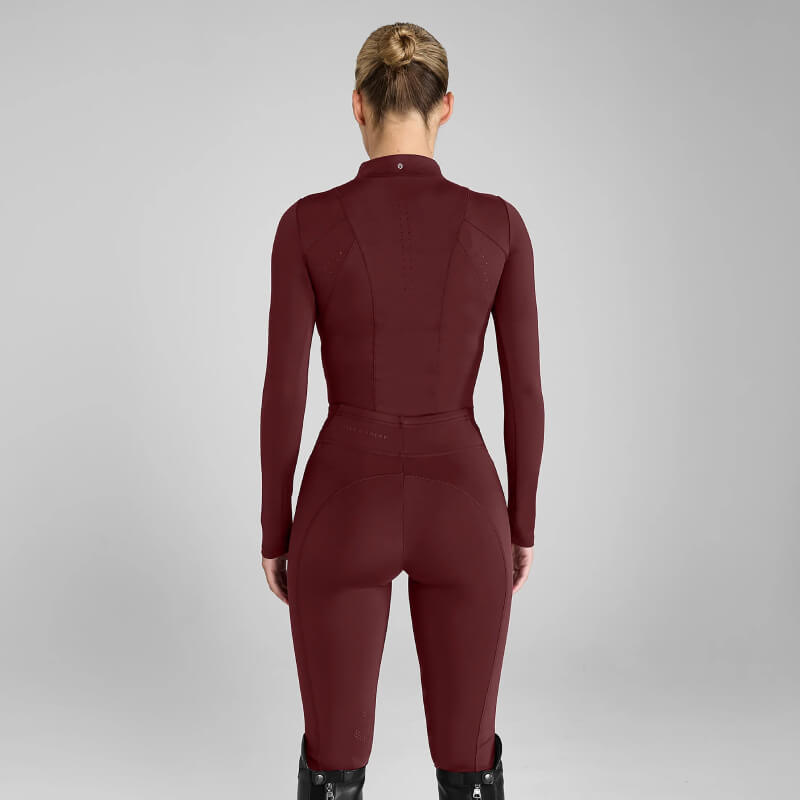 Person in Aztec Diamond Core Leggings Knee Grip Cherry and tall black boots, back to camera.