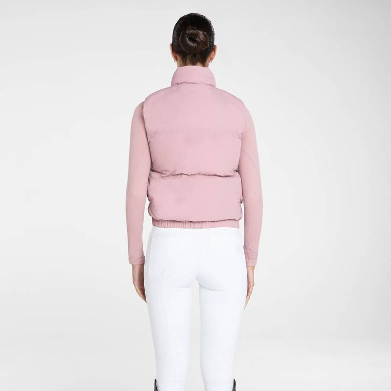 Person in an Aztec Diamond Pink Core Mid-layer Gilet and white pants, facing away.