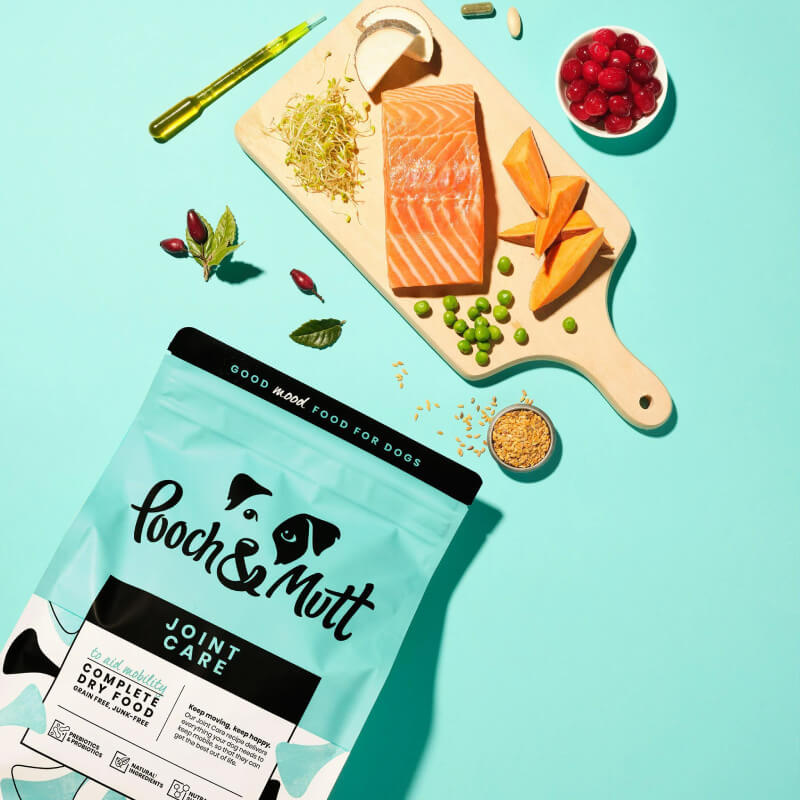 Pooch & Mutt Joint Care Premium Dog Food 2kg with salmon, sweet potato & veggies on blue.