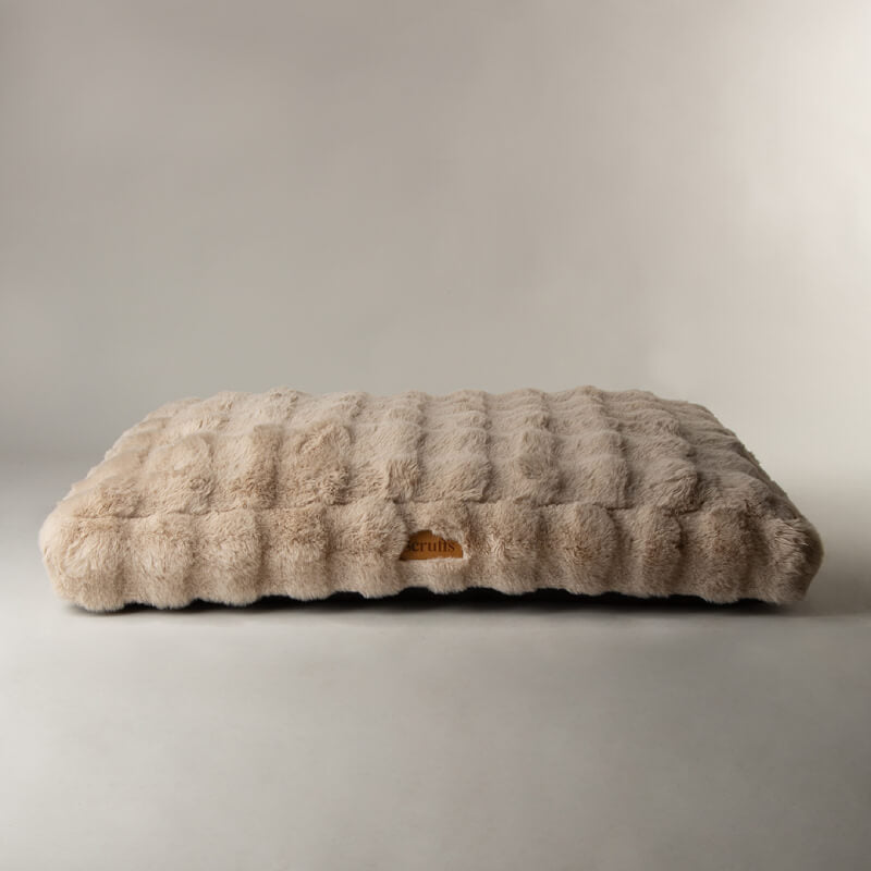 The Scruffs Alpine Mattress Champagne, a rectangular faux fur dog bed, sits on a light background.