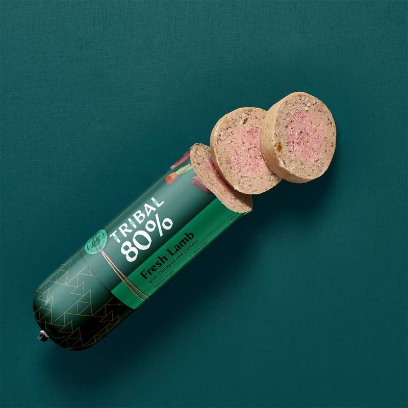Tribal 80% Dog Sausage 300g sliced on green background, hypoallergenic dog food.