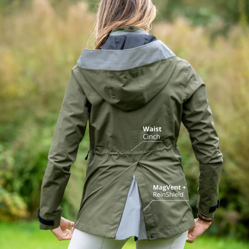 Woman outdoors in Reinwear Reincoat Air Adult Olive with waist cinch and back vent features.