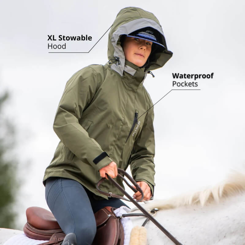 Person riding a horse in a Reinwear Reincoat Air Adult Olive with XL hood and waterproof pockets.