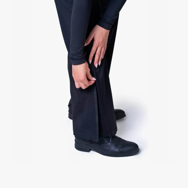 Wearing Reinwear Reinpants Lite Black, person unzips lower leg over black shoes.
