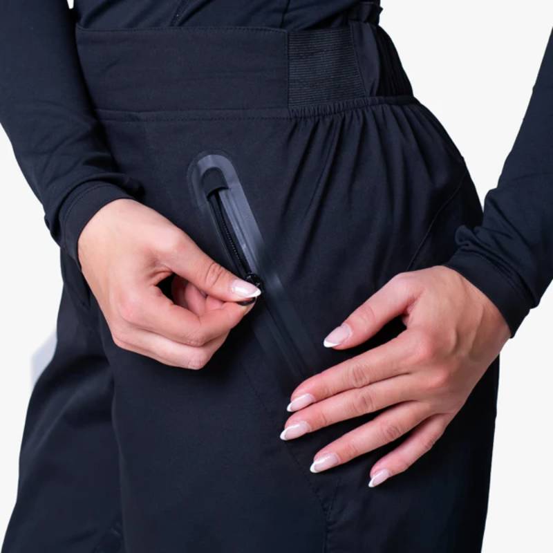 Close-up of a person opening a zip pocket on Reinwear Reinpants Lite Black rain pants.