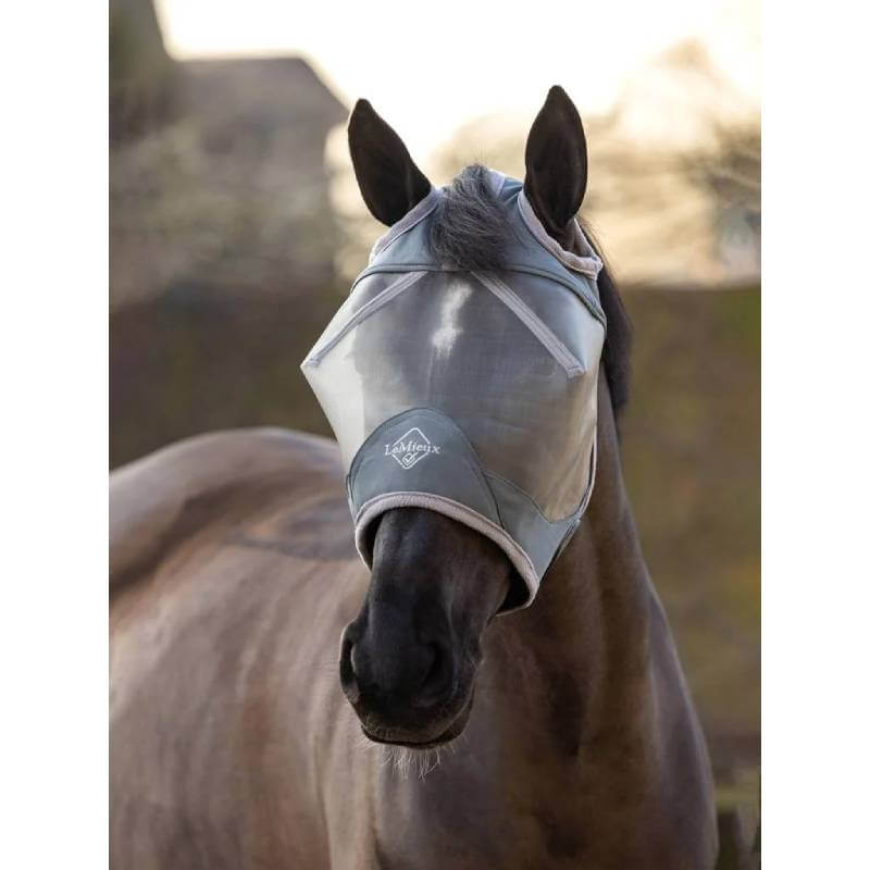 A horse wears the LeMieux Armourshield Pro Standard Fly Mask Grey outdoors.