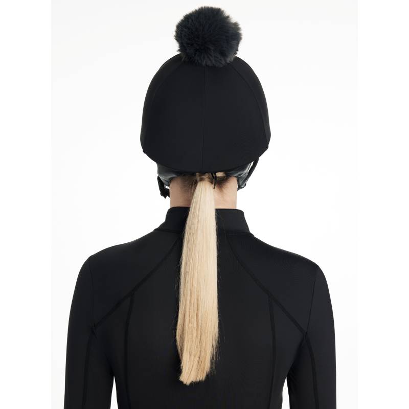 Person in a LeMieux Classique Pom Hat Silk Black, seen from behind with a blond ponytail.