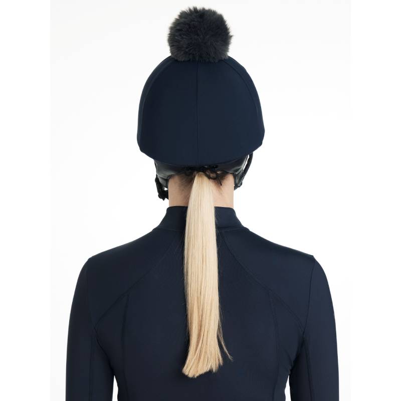 Woman in LeMieux Classique Pom Hat Silk Navy with detachable faux fur pom, facing forward.