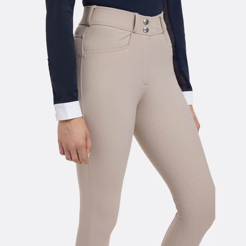 Woman wearing LeMieux Isabelle Full Seat Breeches Almond with double-button closure.