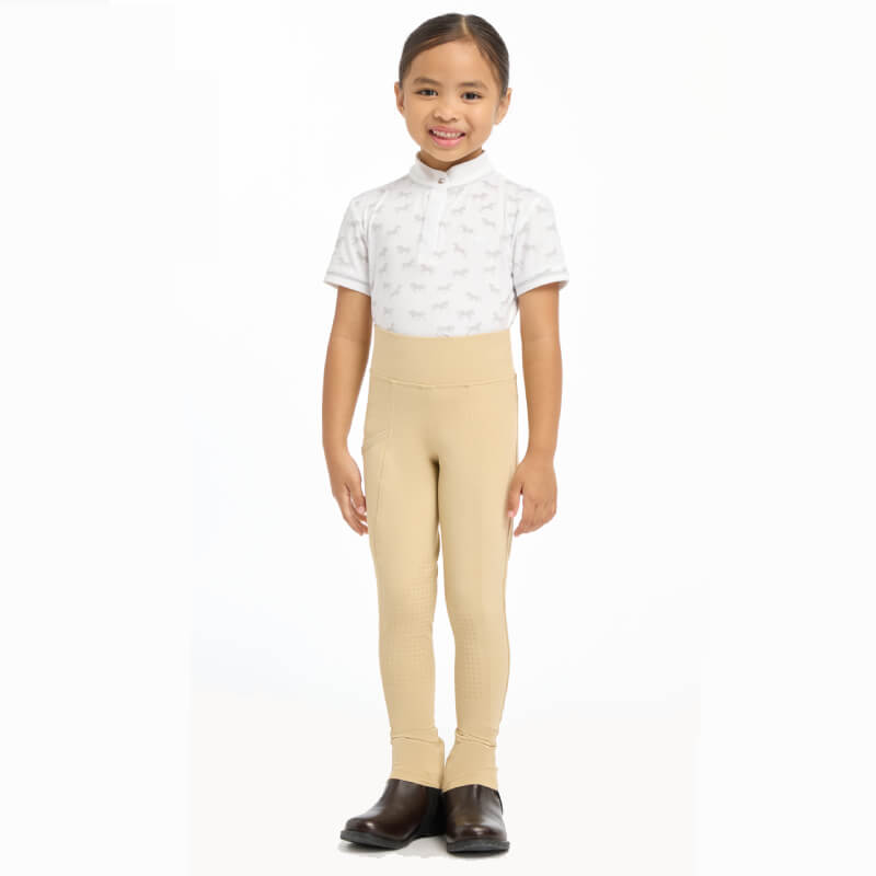 Smiling young girl in a white shirt and LeMieux Mini Pull On Breech Beige.