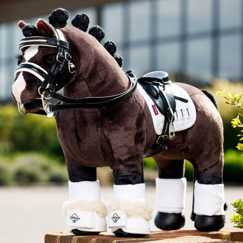 LeMieux Toy Pony wears white Dressage Over Reach Boots by LeMieux, outdoors.
