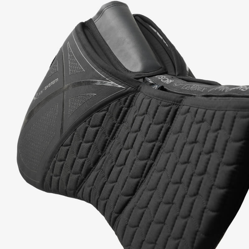Someone inserts a LeMieux ProSorb Black Quilted Half Pad into a saddle pad.
