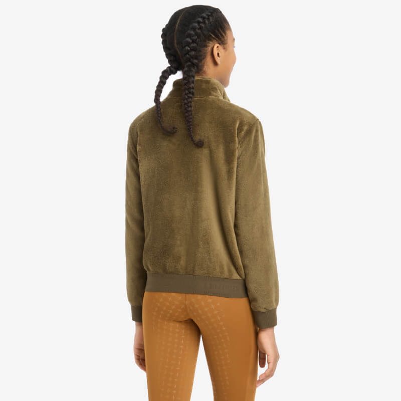 Young rider with braided hair in a LeMieux Young Rider Libby Fleece Alpine, shown from the back.