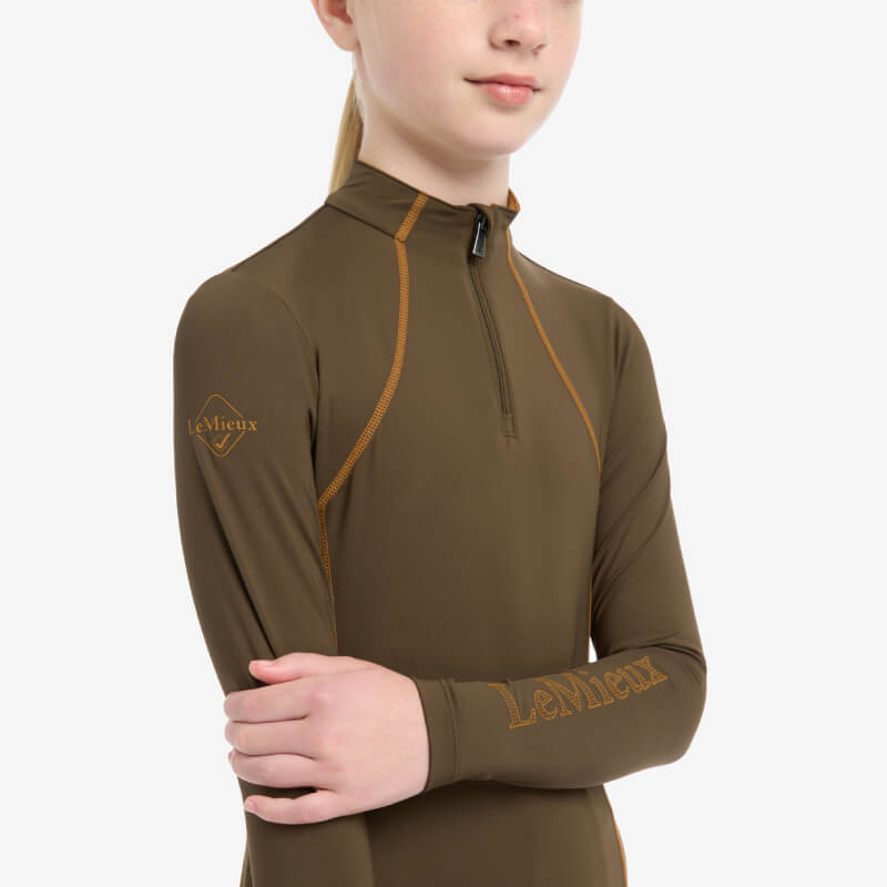 Young rider in LeMieux Young Rider Baselayer Alpine, arms crossed, on a white background.
