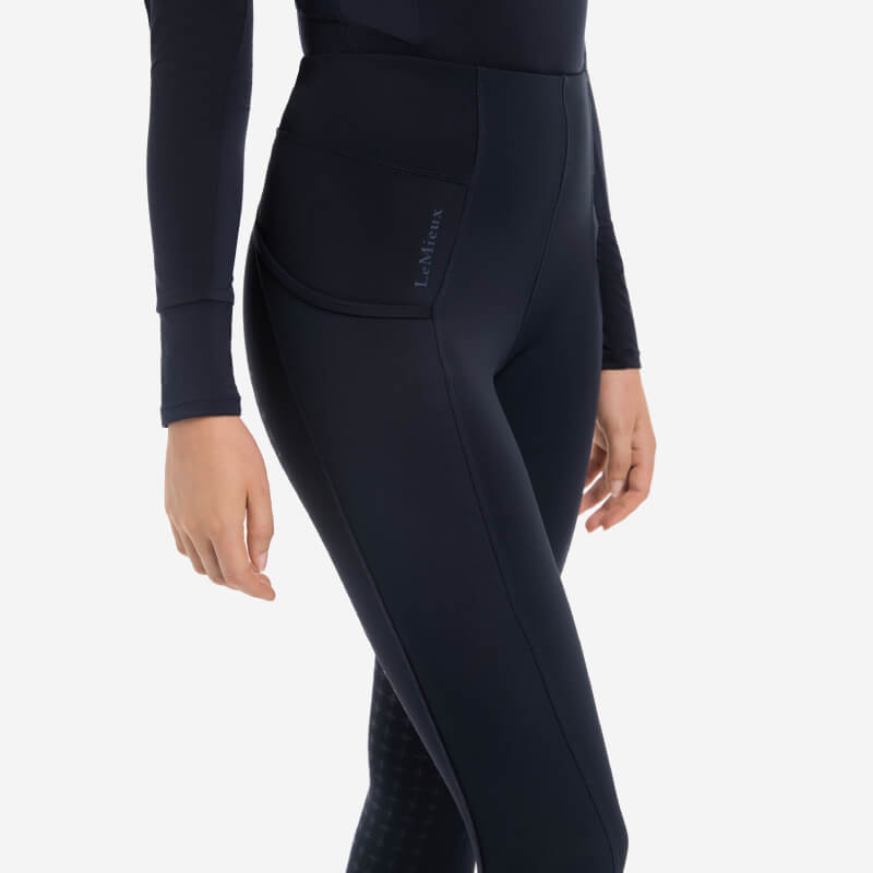 Model in LeMieux Naomi Pull On Breech Navy Full Seat, shown waist to mid-thigh with side pocket.