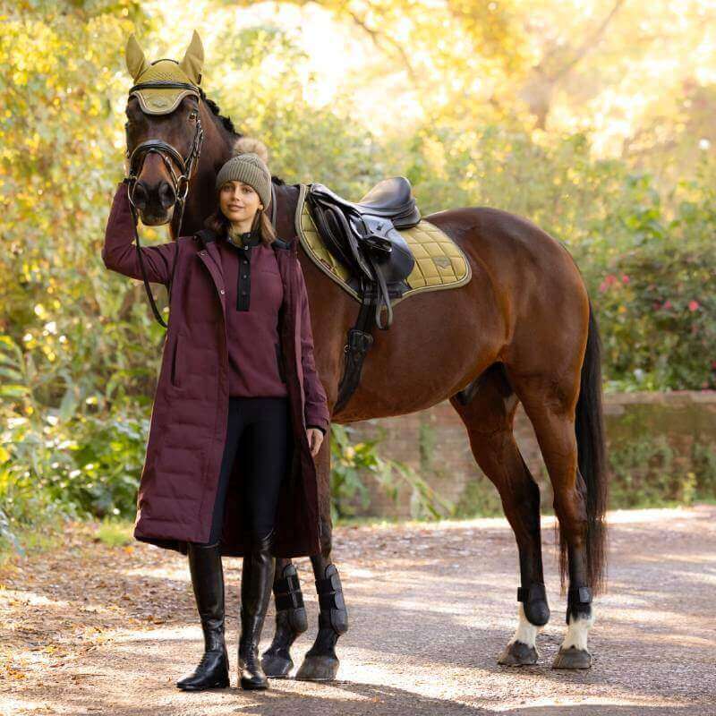 Woman in coat and beanie stands by horse with LeMieux Loire Classic Close Contact Square Gooseberry.