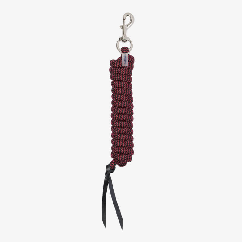 Person holding a LeMieux Training Leadrope Black/Red with metal clip, on grass in riding boots.