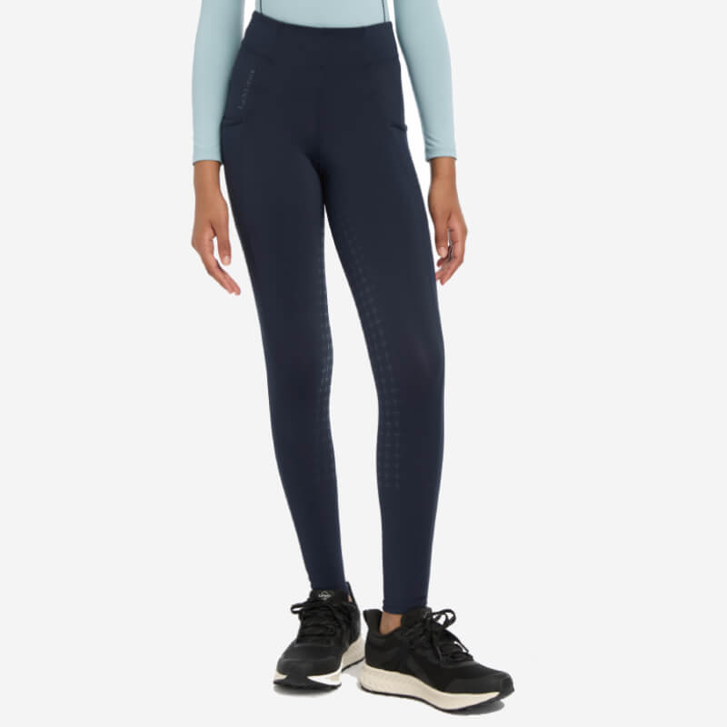 Person in LeMieux Young Rider Orla Pull Ons Navy leggings, black sneakers, and a light blue top.