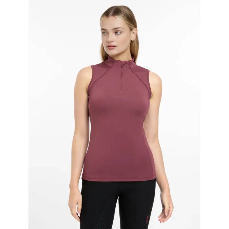 Woman in LeMieux Maria Mesh Sleeveless Baselayer Rosewood on a grassy field.