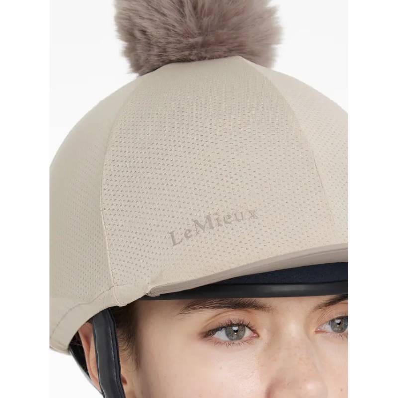 Close-up of the LeMieux Maria Mesh Hat Silk Almond with fluffy pom-pom and LeMieux branding.