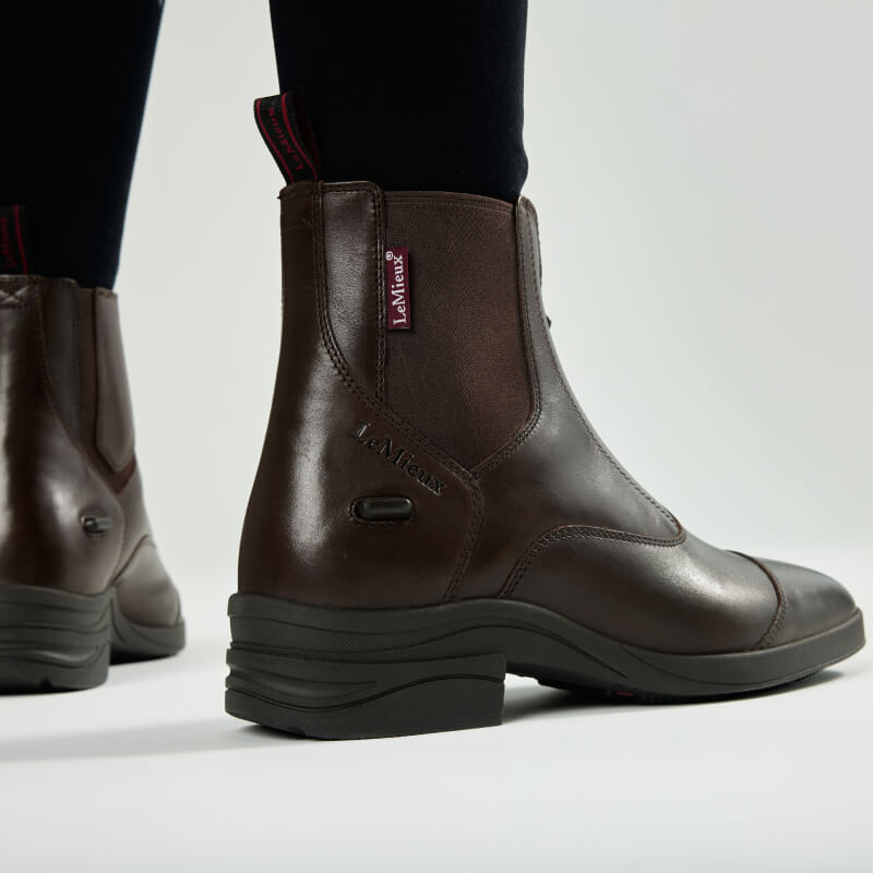 LeMieux Adults Zip Paddock Boot Brown with black pants, brand logo visible.