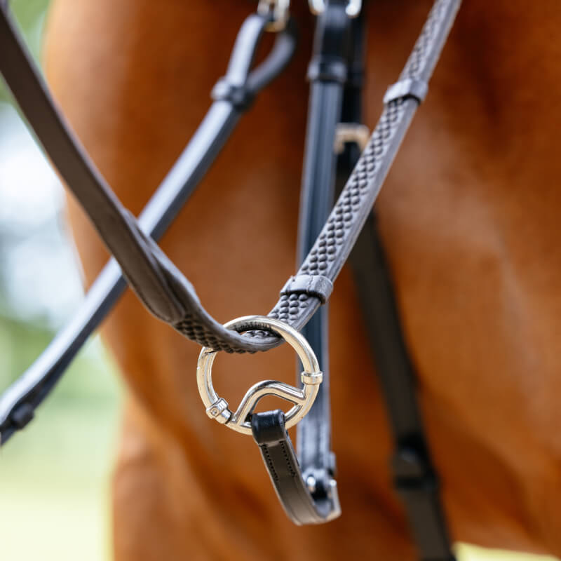 Close-up of LeMieux Kudos Bridge Breastplate Black and reins on a brown horse.