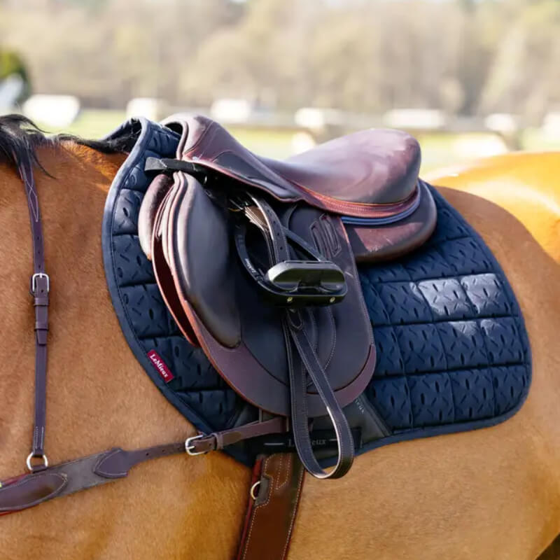 LeMieux 3D Mesh Self-Cool Eurojump Square Navy pad on horse with brown saddle, outdoors.
