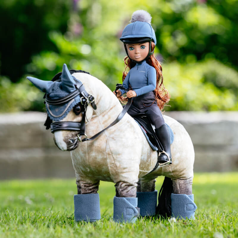 LeMieux Toy Rider Olivia doll wears a blue helmet, jacket, gray pants, and black boots.