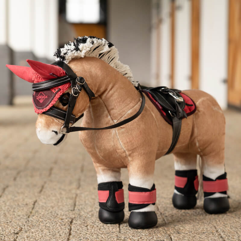 LeMieux Toy Pony Oskar: plush horse with red and black saddle, bridle, and leg wraps.