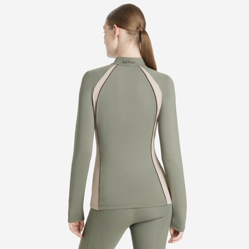 Woman wears LeMieux Phillipa Mesh Baselayer Rosemary, shown from the back on white background.