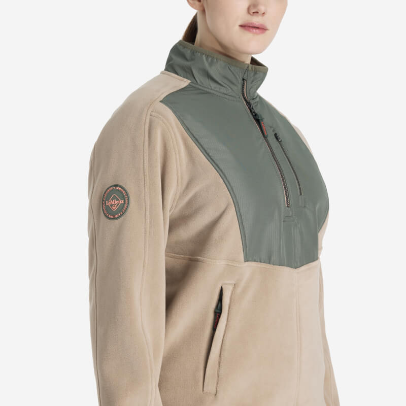 Woman in the LeMieux Clara Hybrid Fleece Rosemary, a stylish transitional jacket by LeMieux.