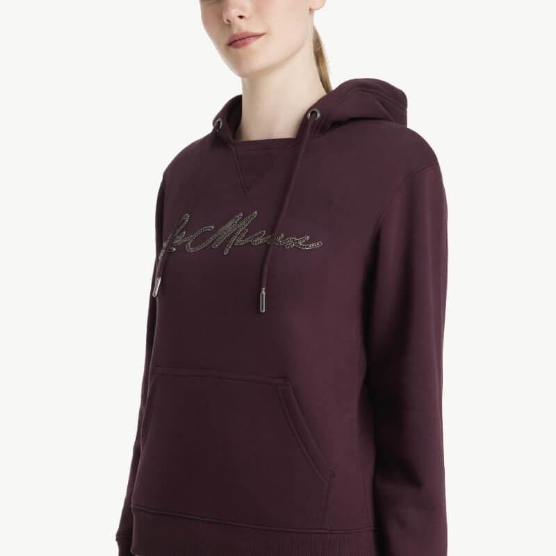 Woman in a LeMieux Elspeth Hoodie Damson with front pocket and chest text.