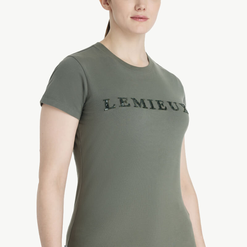Woman in a LeMieux Classique Sparkle T-Shirt Rosemary and maroon pants on a white background.