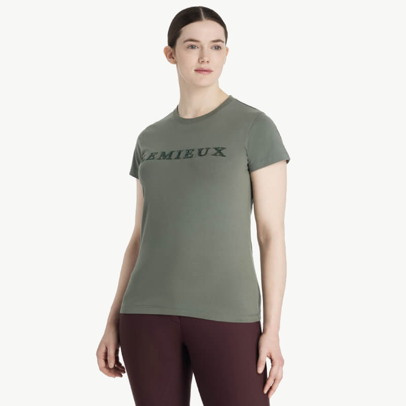 Woman in a LeMieux Classique Sparkle T-Shirt Rosemary and maroon pants on a white background.