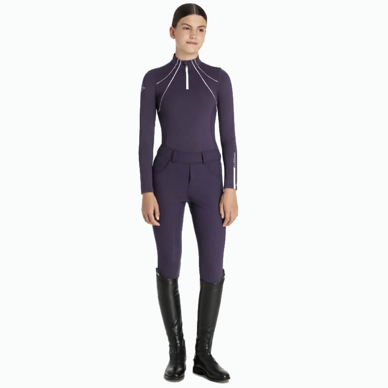 Woman in a LeMieux Young Rider Mia Mesh Baselayer Juniper with long sleeves and zip collar.