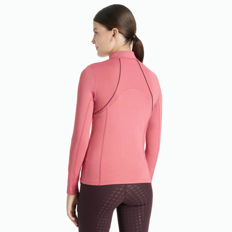 Young rider in a LeMieux Mia Mesh Baselayer Cranberry, brown hair in ponytail, seen from back.
