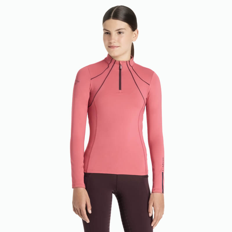 Girl wearing LeMieux Young Rider Mia Mesh Baselayer Cranberry, facing forward in dark leggings.