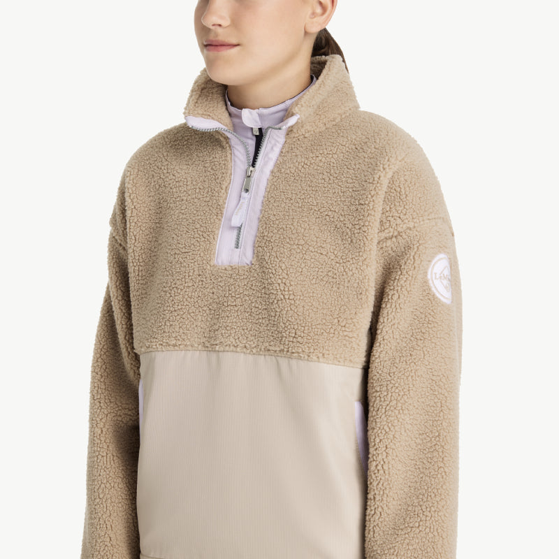 Smiling young woman in LeMieux Young Rider Tammy Teddy Fleece Almond and purple leggings.