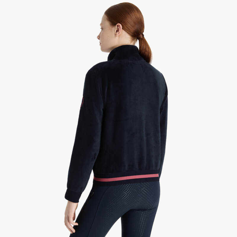 Girl with brown ponytail wears LeMieux Young Rider Libby Fleece Navy, shown from the back.