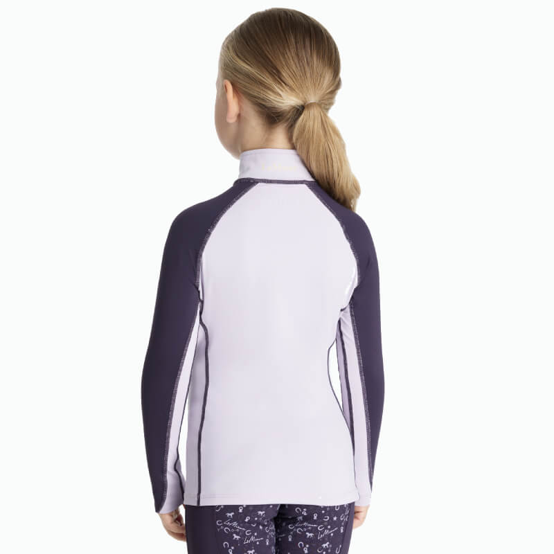 Smiling girl in LeMieux Mini Baselayer Lilac athletic top with UV50+ protection.