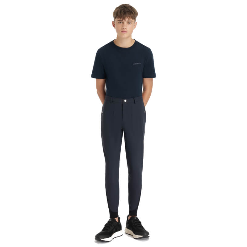 Teen boy models LeMieux Young Rider Boys Classique Breech Navy, hands behind back, white bg.