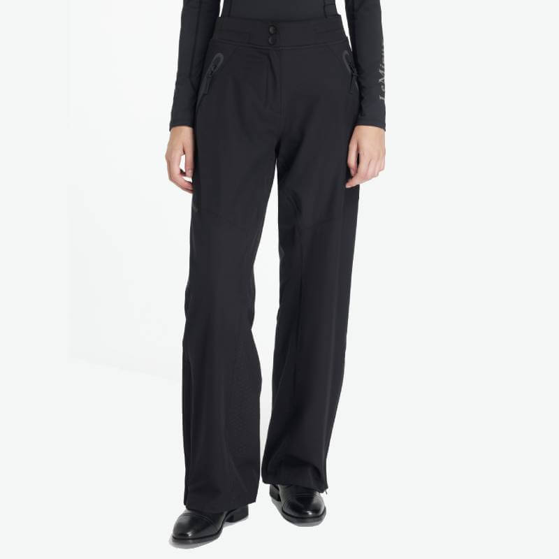 Wearing LeMieux Stormwear Waterproof Trousers Black with silicone knee grips and black shoes.