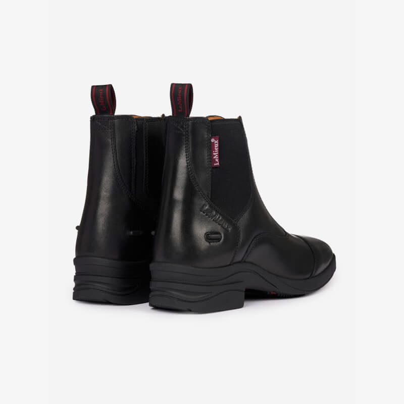 LeMieux Junior Zip Paddock Boot Black—black leather with elastic sides and red pull tabs, rear view.