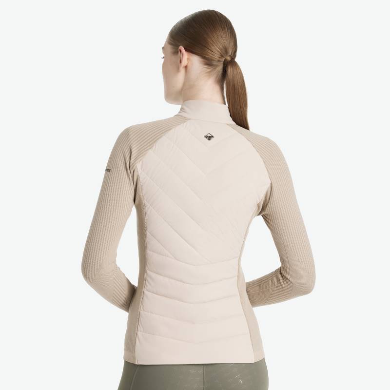 Woman in LeMieux Maddie Jacket Stone by LeMieux, hair tied, against a white background.