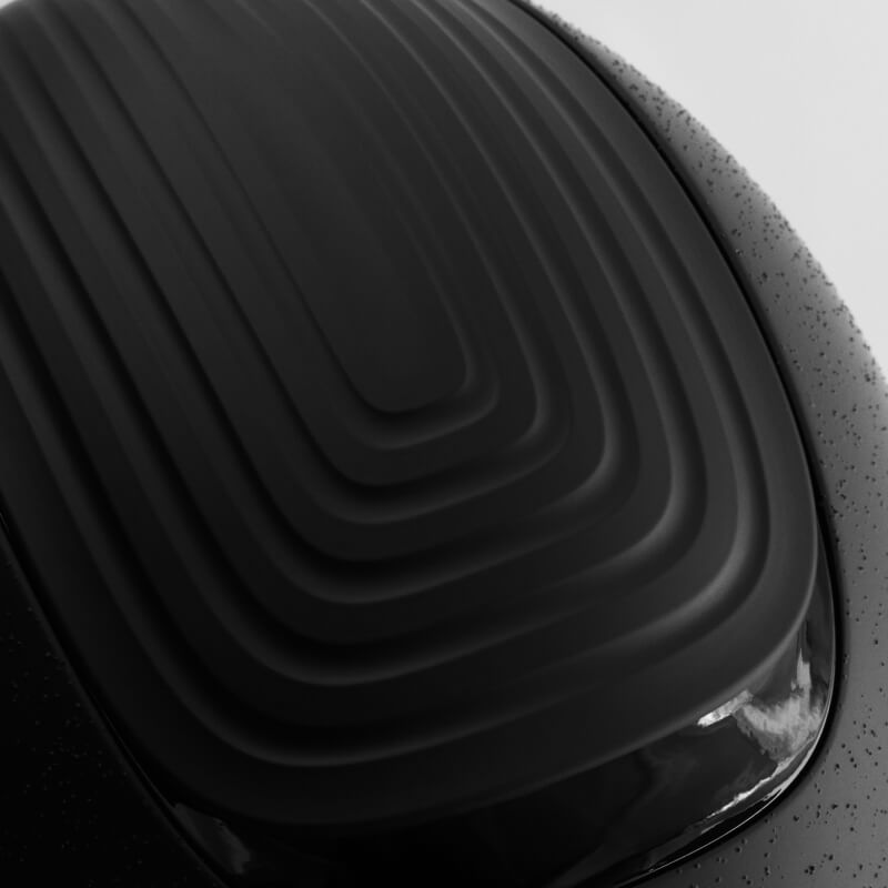 Close-up of the LeMieux Vexa® Skull Helmet Black with rectangular ridges and water droplets.